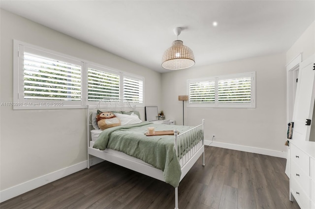 bedroom with baseboards and dark wood-type flooring