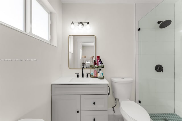 bathroom with tiled shower, toilet, and vanity