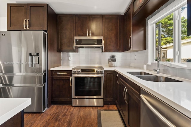 kitchen featuring dark wood-style floors, appliances with stainless steel finishes, light countertops, and a sink