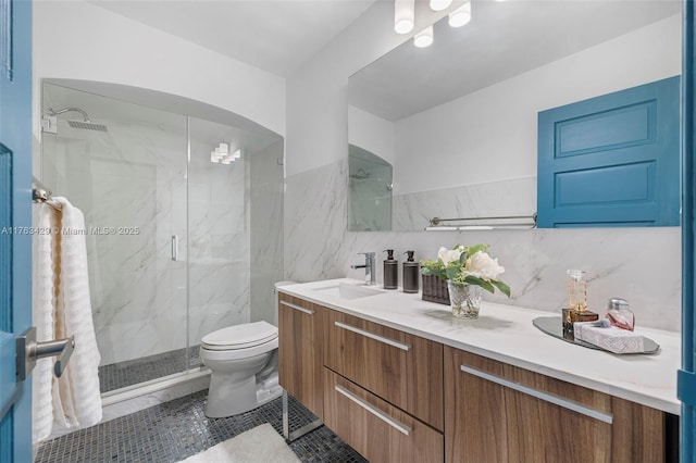 full bathroom with toilet, vanity, a marble finish shower, decorative backsplash, and tile walls