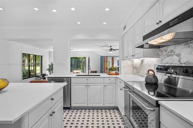 kitchen featuring white cabinets, light countertops, stainless steel appliances, and under cabinet range hood
