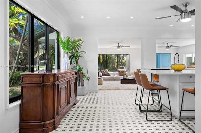 interior space featuring recessed lighting, crown molding, baseboards, and ceiling fan