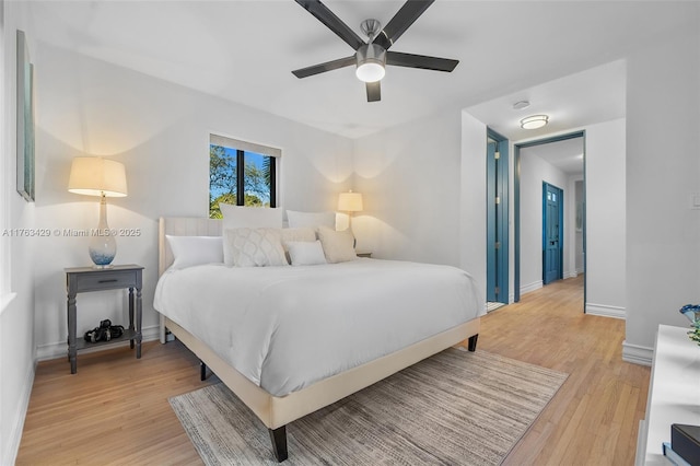 bedroom with a ceiling fan, baseboards, and light wood-type flooring