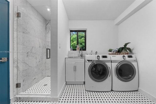clothes washing area featuring a sink, cabinet space, baseboards, and washer and clothes dryer