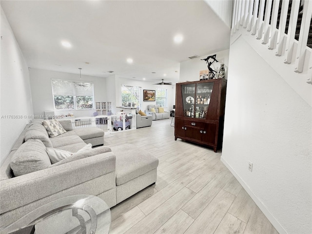 living area featuring visible vents, baseboards, ceiling fan, light wood-type flooring, and recessed lighting