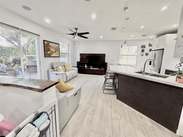 living area featuring light wood finished floors, visible vents, recessed lighting, and ceiling fan