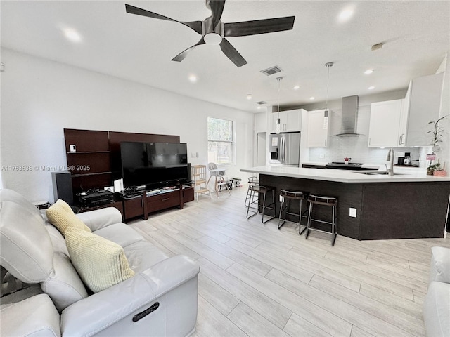 living area featuring wood finish floors, recessed lighting, visible vents, and ceiling fan