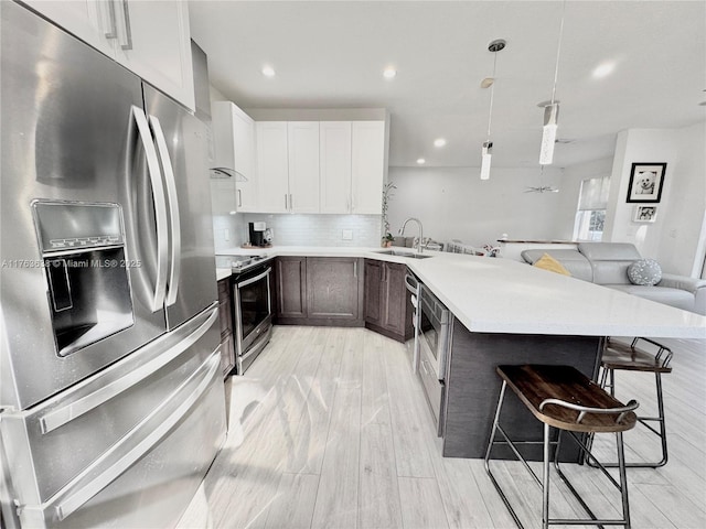 17130 SW 36th Ct Unit 17130, Miramar, FL 33027 - kitchen with backsplash, a breakfast bar area, a peninsula, stainless steel appliances, and a sink
