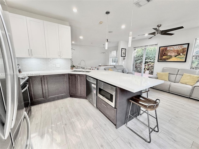 kitchen with a sink, visible vents, open floor plan, and stainless steel appliances