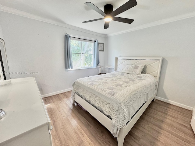 bedroom featuring a ceiling fan, light wood-style floors, baseboards, and ornamental molding