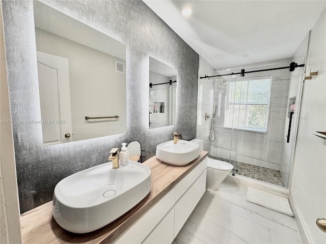 bathroom featuring visible vents, double vanity, a sink, a shower stall, and marble finish floor