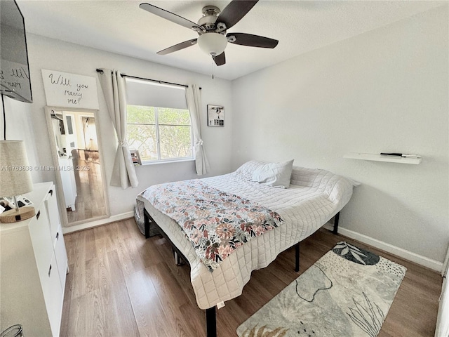 bedroom with light wood-type flooring, baseboards, and ceiling fan