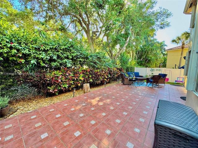 view of patio with an outdoor living space and fence