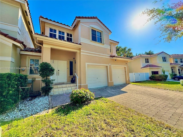 view of front of property featuring stucco siding, decorative driveway, an attached garage, and a tile roof