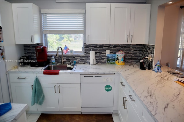 kitchen with dishwasher, light stone counters, decorative backsplash, white cabinetry, and a sink