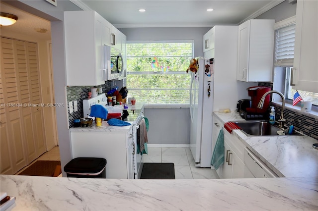 kitchen featuring a sink, decorative backsplash, white appliances, and light stone countertops