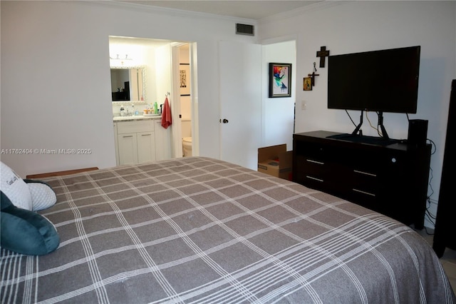 bedroom with visible vents, connected bathroom, and crown molding