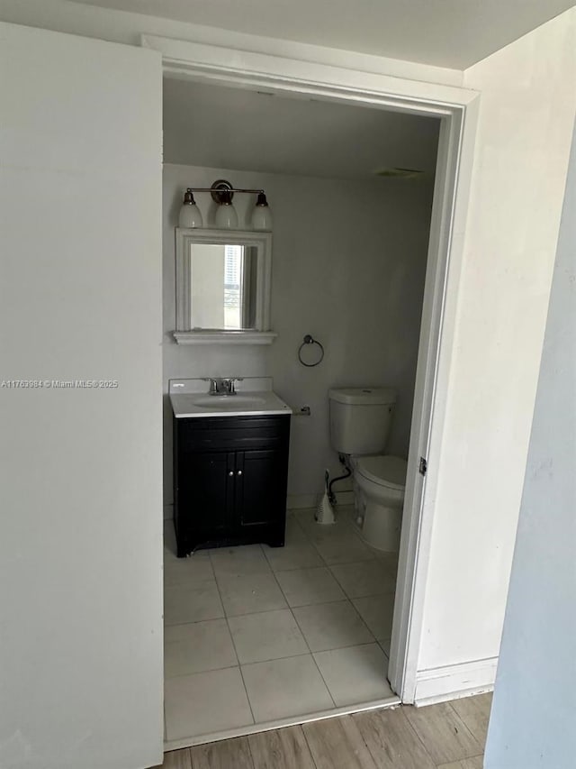 bathroom featuring vanity, toilet, and wood finished floors