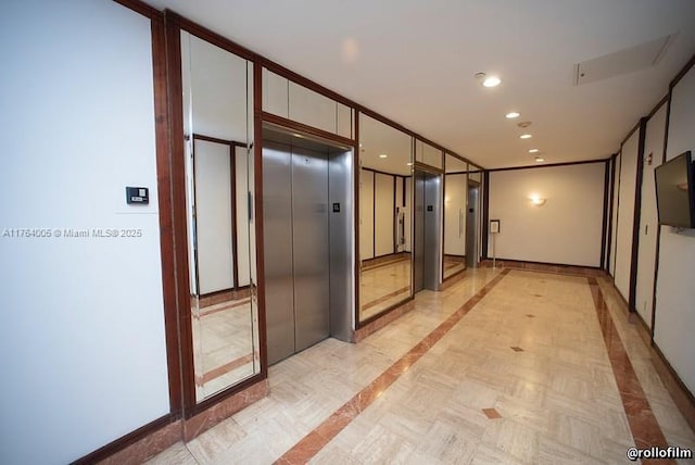 hall with elevator, recessed lighting, and baseboards