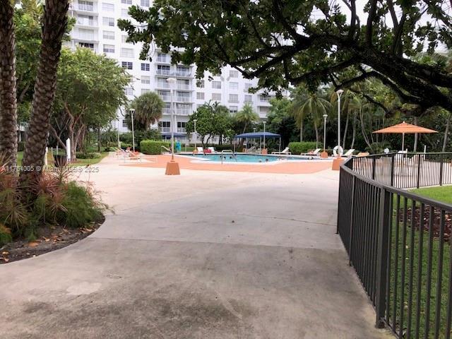 view of community featuring a pool and fence