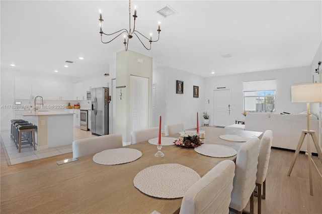 dining area with an inviting chandelier, recessed lighting, light wood-style floors, and visible vents