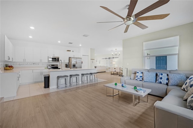 29081 SW 168th Ct, Homestead, FL 33030 - living room with a chandelier, a ceiling fan, light wood-style floors, and recessed lighting