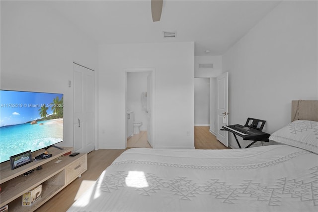 bedroom with ceiling fan, visible vents, ensuite bathroom, and light wood-type flooring