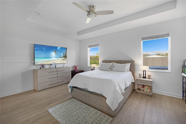 29081 SW 168th Ct, Homestead, FL 33030 - bedroom featuring a tray ceiling, wood finished floors, baseboards, and a ceiling fan