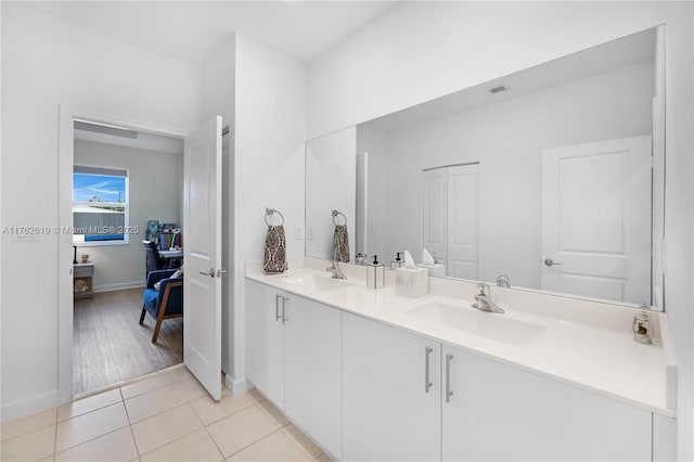 bathroom featuring a sink, visible vents, double vanity, and tile patterned floors