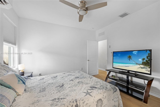 bedroom with visible vents, wood finished floors, and a ceiling fan