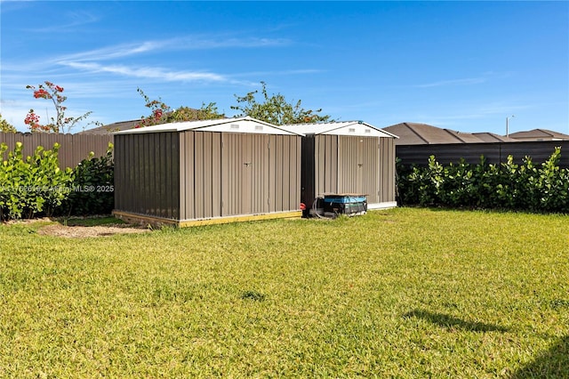 view of yard featuring an outdoor structure, fence, and a shed