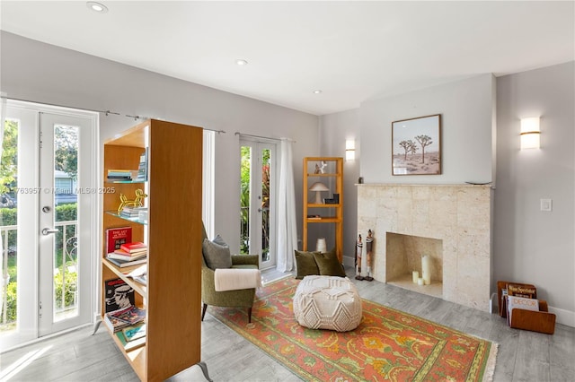 living area featuring recessed lighting, wood finished floors, and a tile fireplace