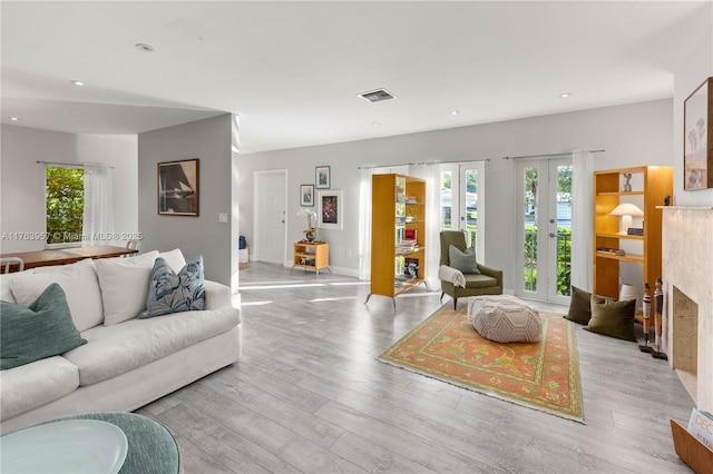 living area with visible vents, recessed lighting, french doors, and wood finished floors