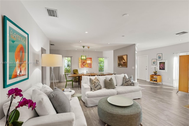 living room with visible vents, recessed lighting, and light wood-type flooring