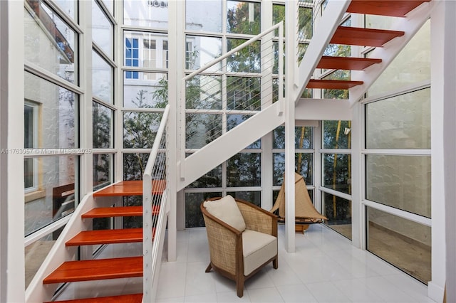 staircase featuring tile patterned flooring and expansive windows