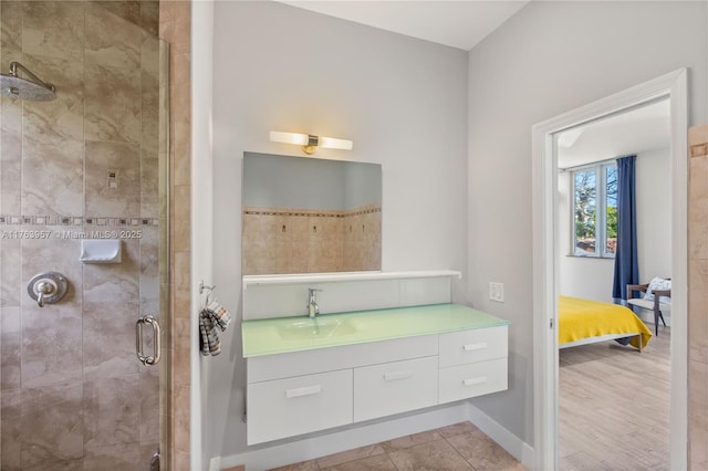 full bath featuring vanity, baseboards, a stall shower, and tile patterned flooring