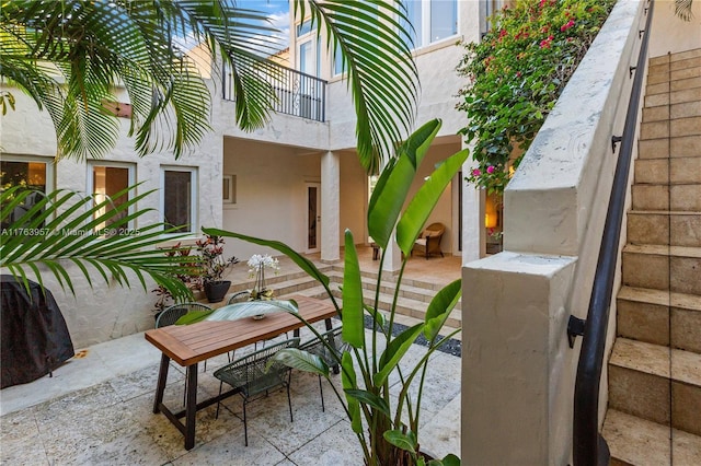 view of patio with outdoor dining area and a balcony