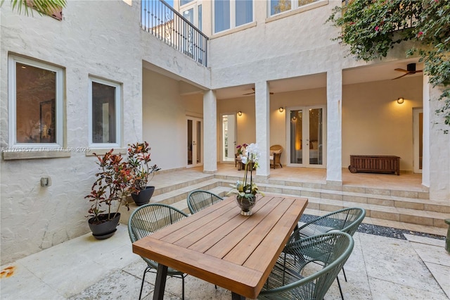 view of patio with french doors, a balcony, and outdoor dining space