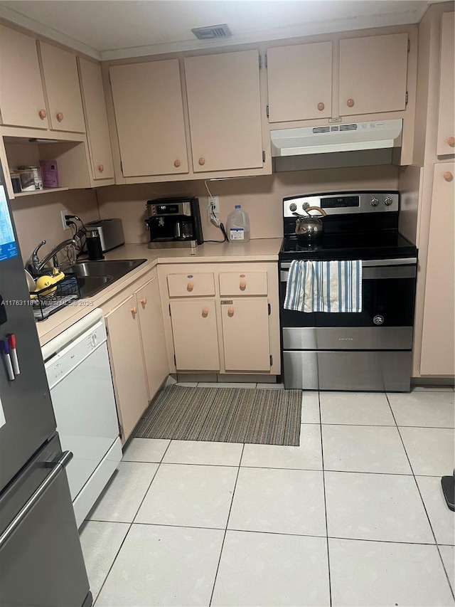 kitchen with under cabinet range hood, appliances with stainless steel finishes, light countertops, and light tile patterned floors