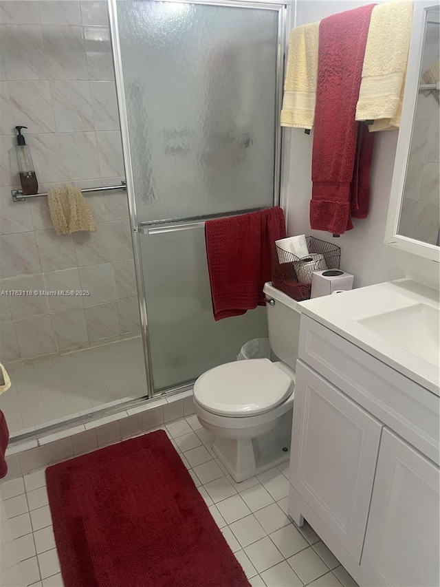 bathroom with tile patterned flooring, a shower stall, vanity, and toilet