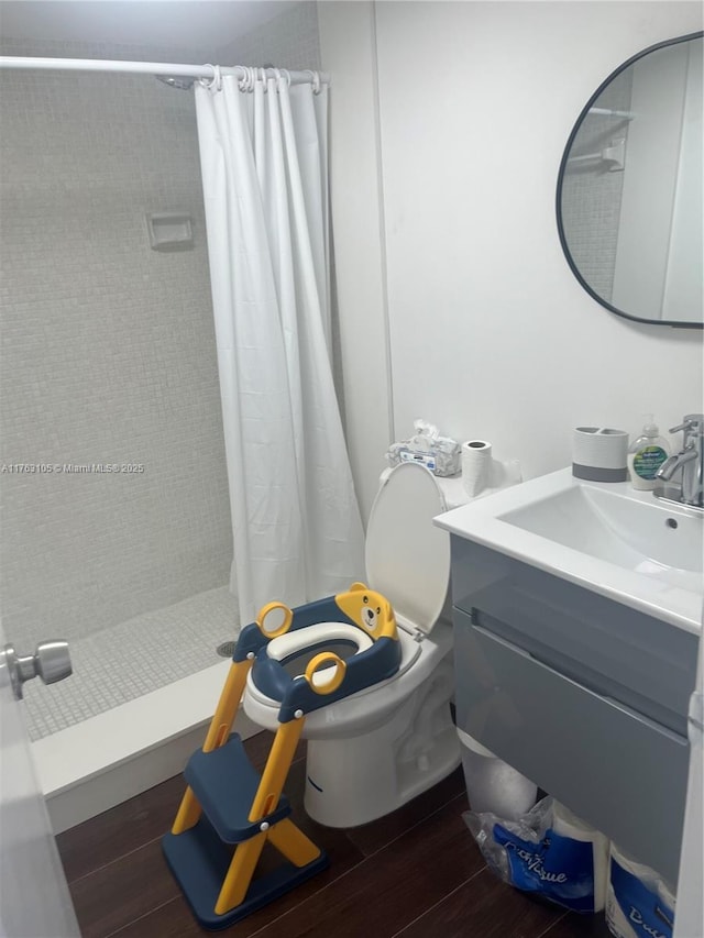 full bathroom with a shower stall, vanity, toilet, and wood finished floors