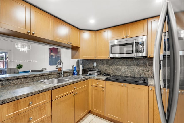 kitchen featuring a sink, dark countertops, tasteful backsplash, and appliances with stainless steel finishes