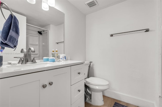 full bathroom featuring visible vents, toilet, wood finished floors, walk in shower, and vanity