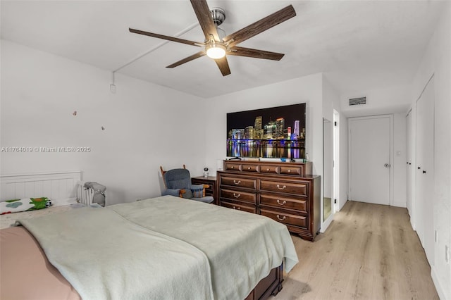 bedroom with visible vents, light wood-type flooring, and a ceiling fan