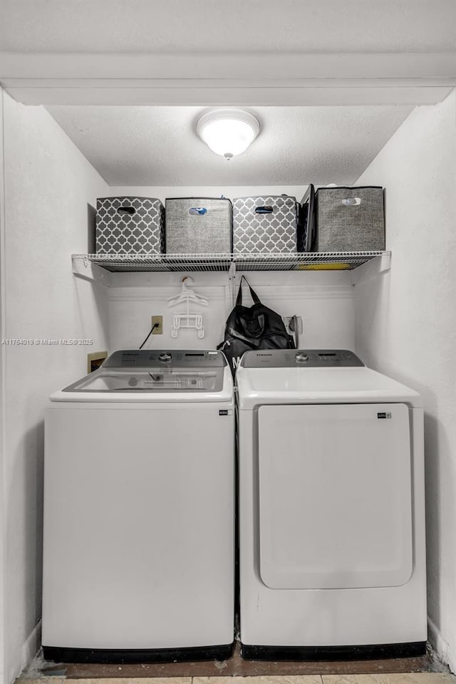 clothes washing area featuring washing machine and clothes dryer and laundry area