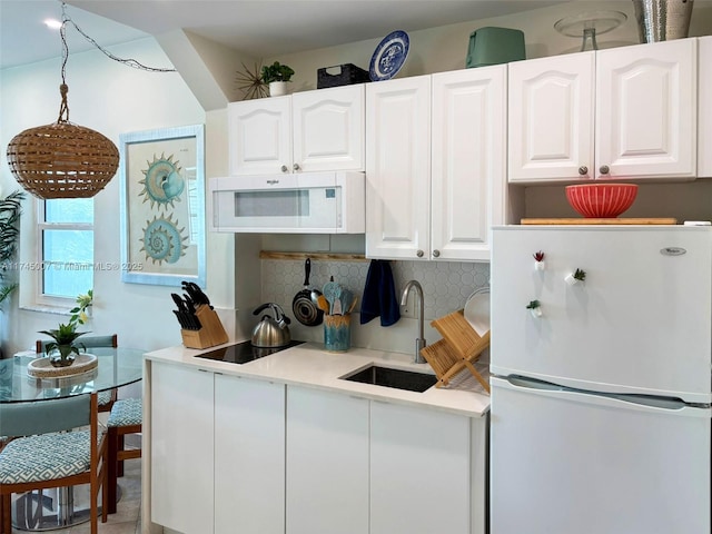 kitchen featuring a sink, white appliances, tasteful backsplash, and white cabinetry