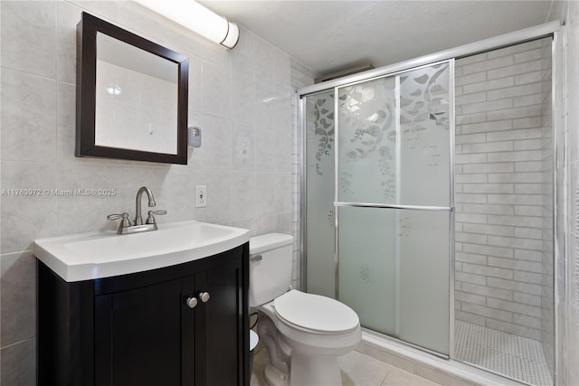 bathroom featuring vanity, tile patterned flooring, a shower stall, tile walls, and toilet