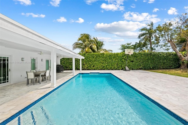 view of pool with outdoor dining space, a ceiling fan, grilling area, a fenced in pool, and a patio area