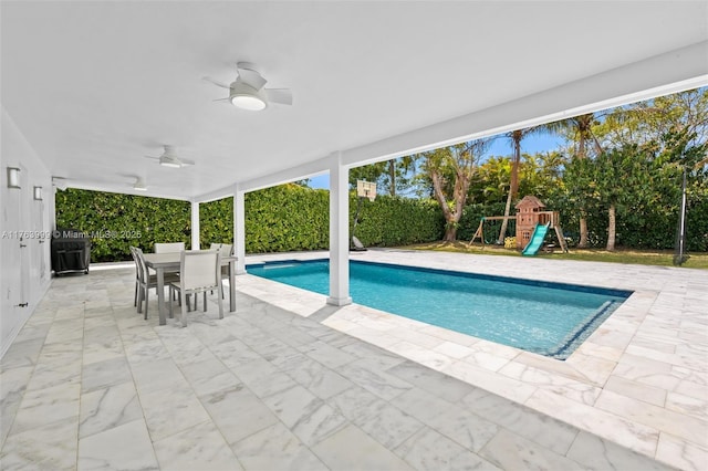 outdoor pool featuring a ceiling fan, a playground, outdoor dining area, and a patio area