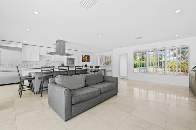 living area with a wealth of natural light, visible vents, and recessed lighting